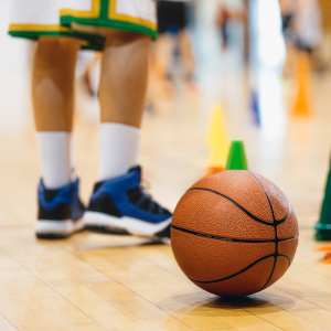 Baseball Pictures for website A kid stands next to a basketball resting on the floor
